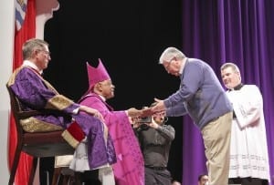 Archbishop Wilton D, Gregory, second from left, returns the Book of the Elect to Ray Hines, the RCIA coordinator at Mary Our Queen Church, Norcross, during the Feb. 22 Rite of Election at the Cobb Galleria Centre. Photo By Michael Alexander
