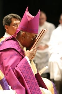During the Feb. 21 Rite of Election and the Call to Continuing Conversion at the Atlanta Civic Center, Archbishop Wilton D. Gregory acknowledges the names in the Book of the Elect with a prayerful kiss of peace.